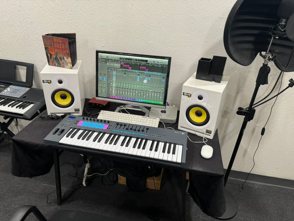 Studio 204 production desk with keyboards, monitors, speakers, and recording microphone.